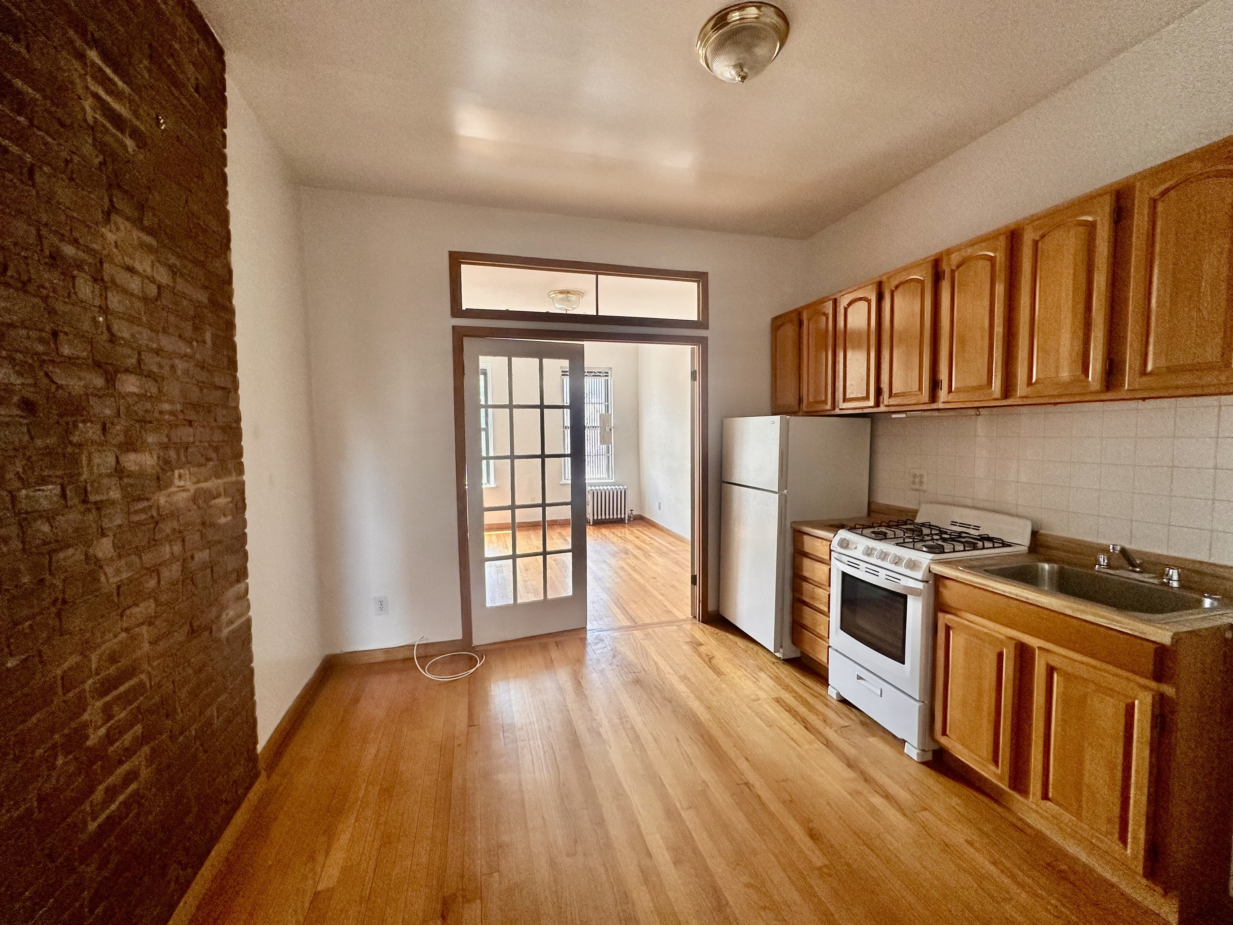 22 St Marks Place, Unit 19 Manhattan, NY 10003 - Photo 1 of 7 a kitchen with a wooden floor and a stove top oven
