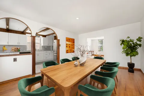 a kitchen with stainless steel appliances kitchen island granite countertop a table and chairs in it