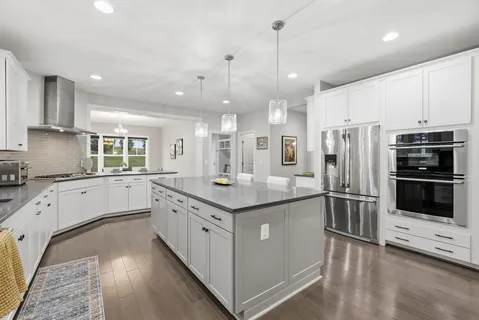 a kitchen with stainless steel appliances granite countertop a stove and a refrigerator