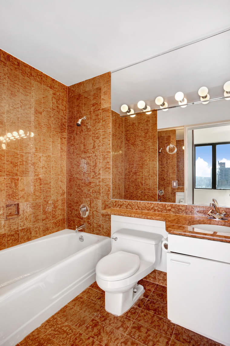 300 East 93rd Street, Unit 35D Manhattan, NY 10128 - Photo 7 of 13 a bathroom with a bathtub a toilet and a shower