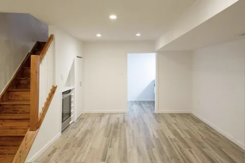 a view of a hallway with wooden floor and staircase