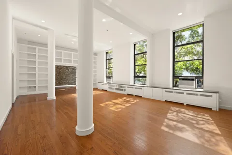 a view of an empty room with a fireplace and a window