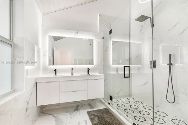 a spacious bathroom with a shower sink and mirror