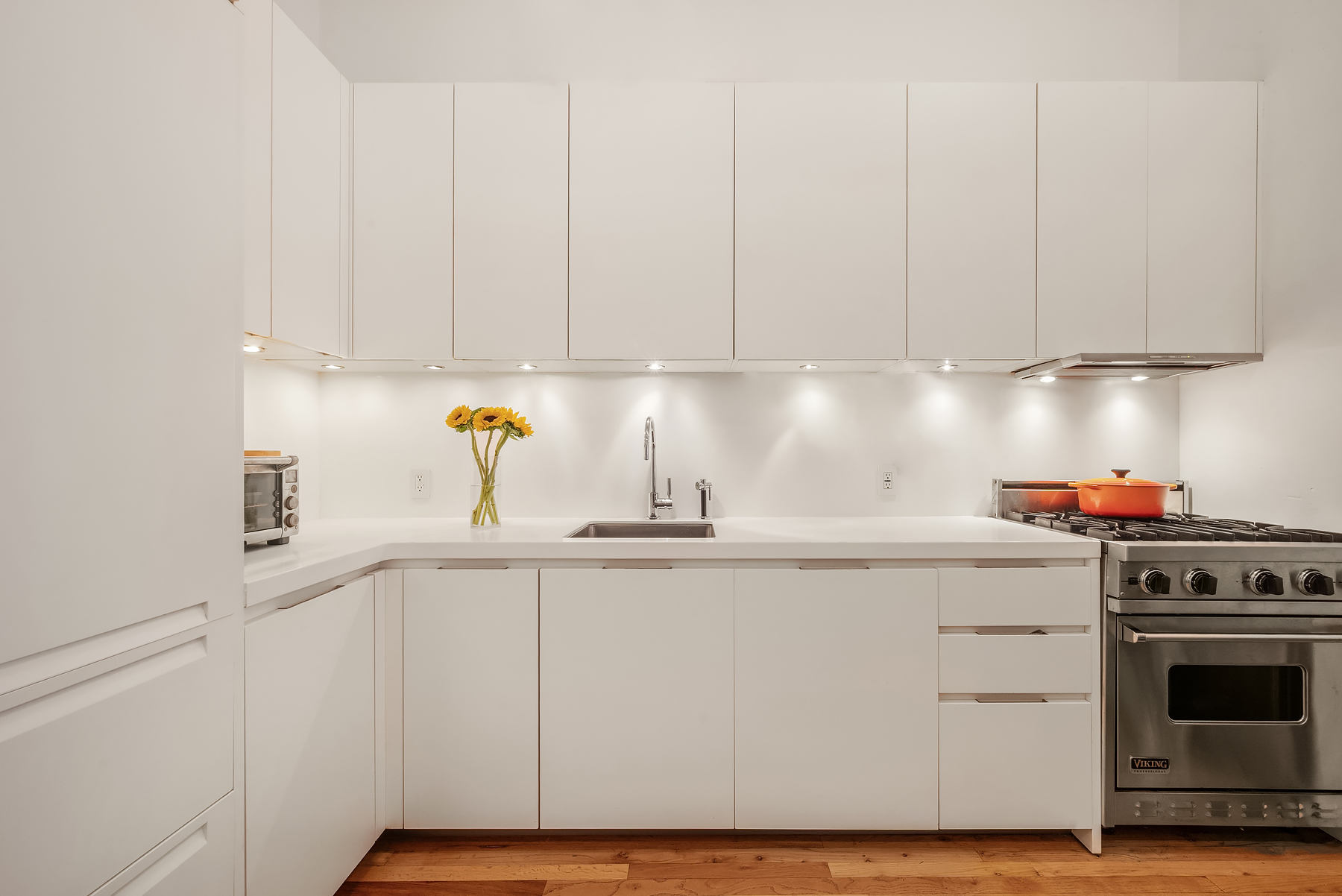 175 East Broadway, Unit 4C Manhattan, NY 10002 - Photo 5 of 14 a kitchen with granite countertop white cabinets and white appliances