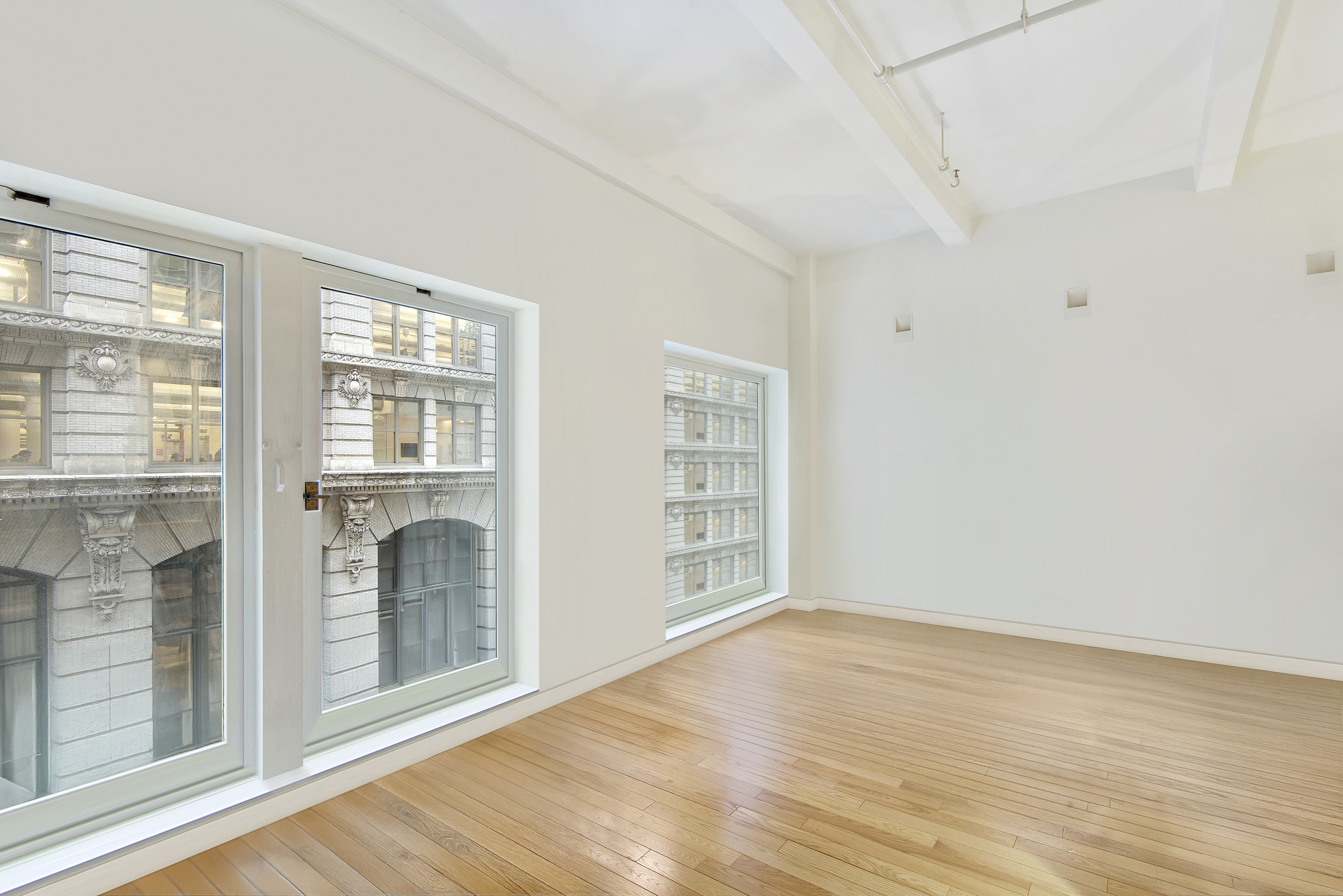 16 West 19th Street, Unit 3A Manhattan, NY 10011 - Photo 3 of 10 a view of an empty room with wooden floor and a window