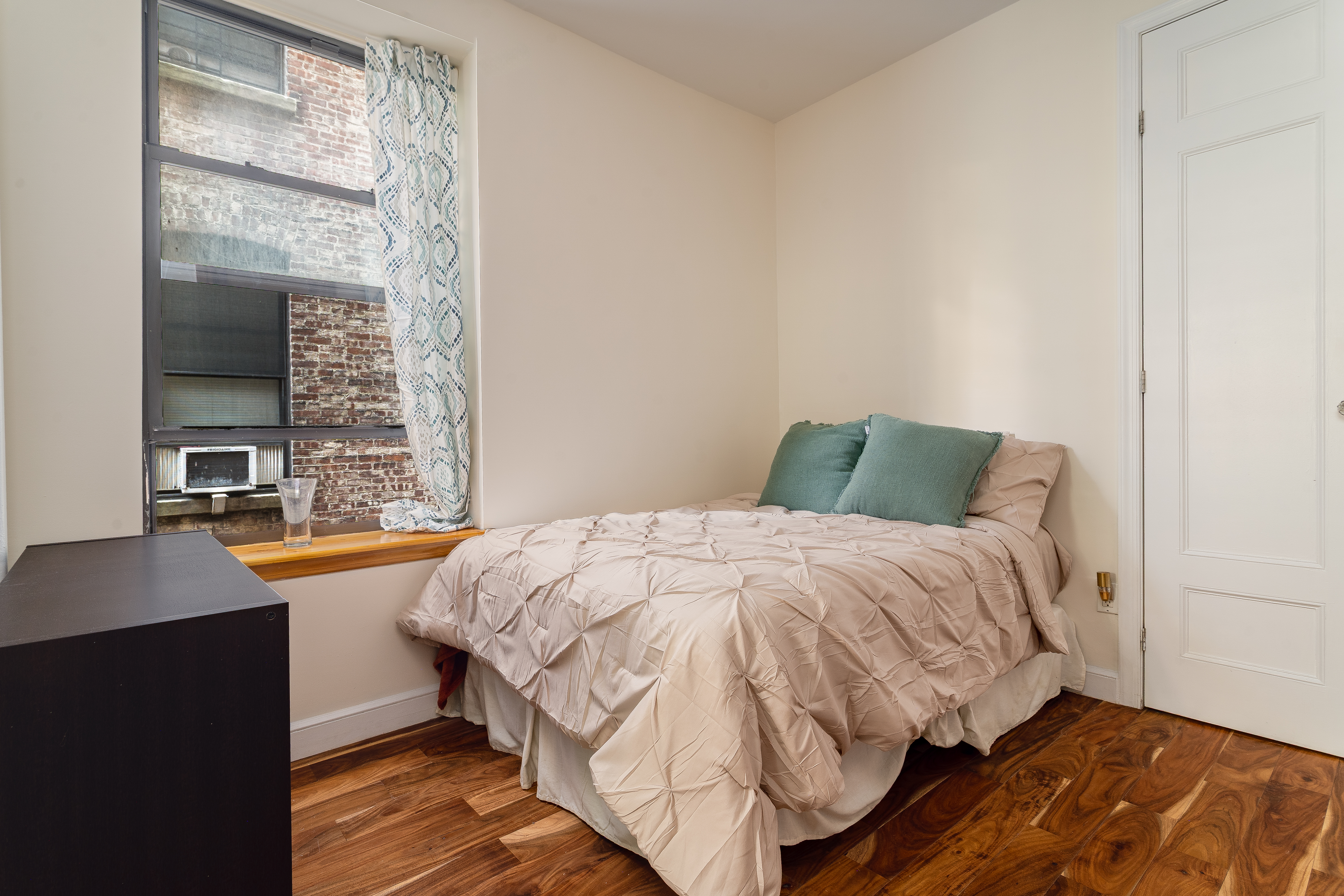 100 West 141st Street, Unit 33 Manhattan, NY 10030 - Photo 7 of 12 a bedroom with a bed and a table in it