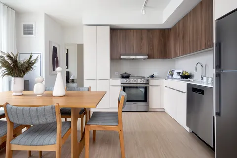 a kitchen with a table chairs sink and cabinets