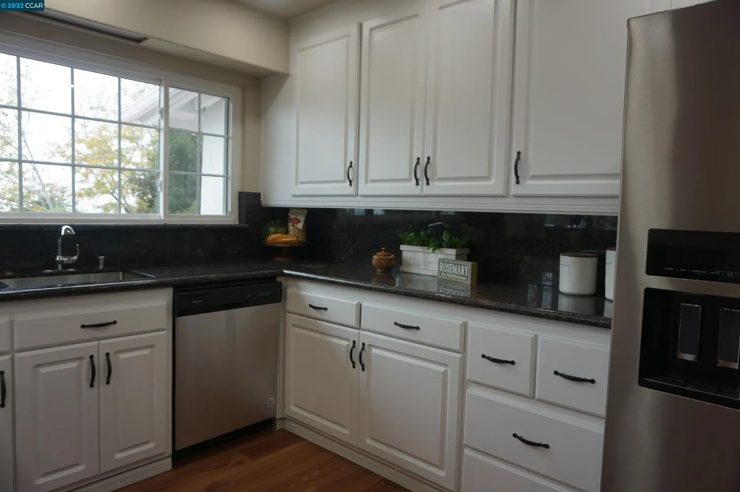 a kitchen with granite countertop white cabinets and sink
