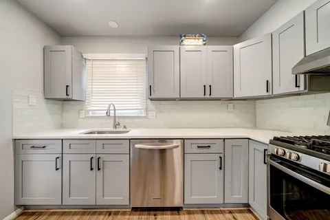 a kitchen with cabinets appliances and a window