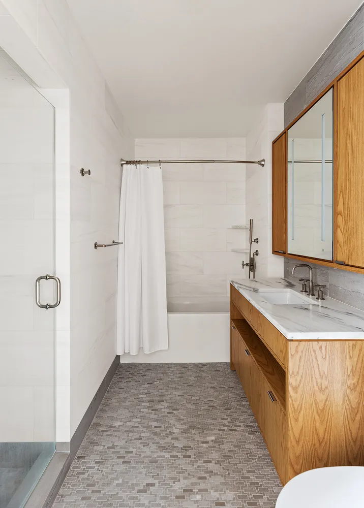 a bathroom with a tub sink and mirror