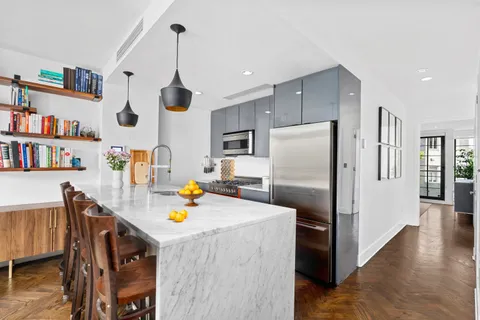 a kitchen with stainless steel appliances refrigerator dining table and chairs