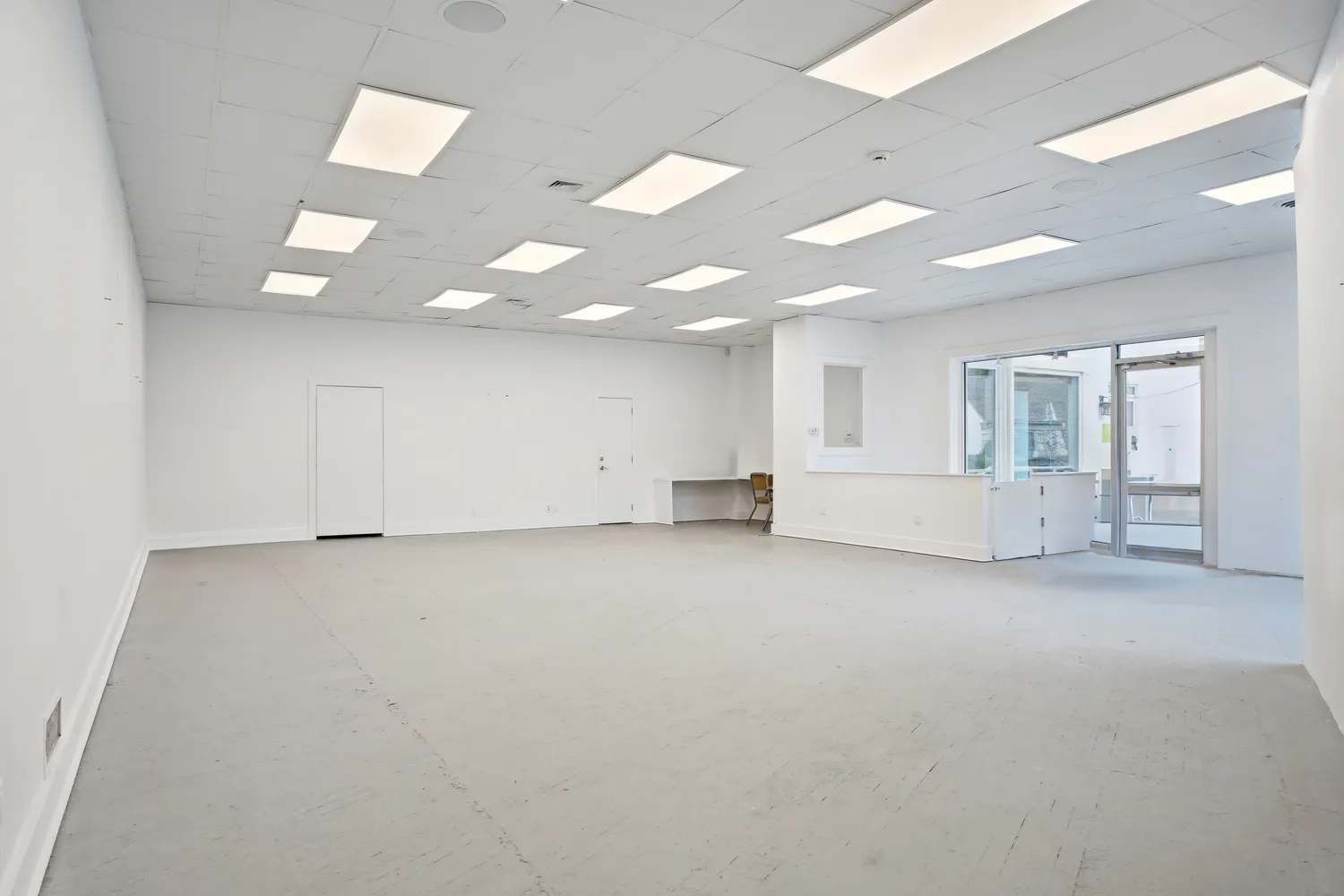 an empty room with white walls and windows