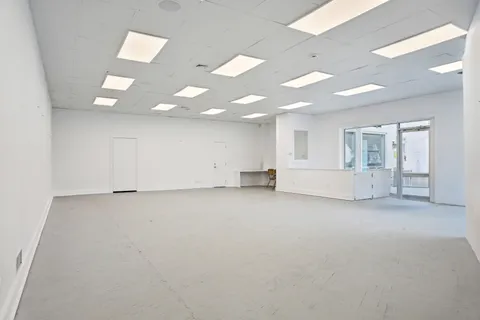 an empty room with white walls and windows