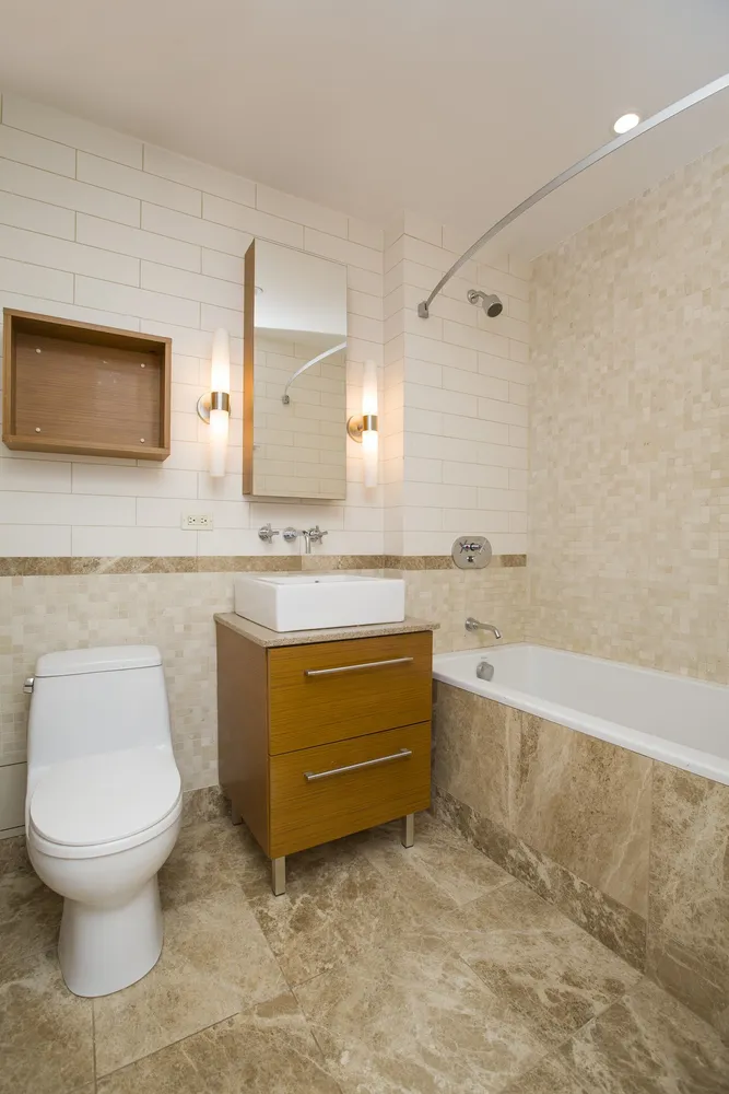 a bathroom with a sink a toilet and mirror