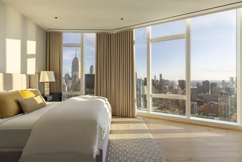 a bedroom with a bed and a large window