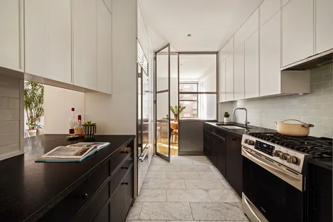 a kitchen with granite countertop a sink stove and refrigerator