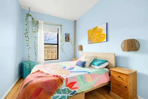 a bedroom with a bed and painting on the wall