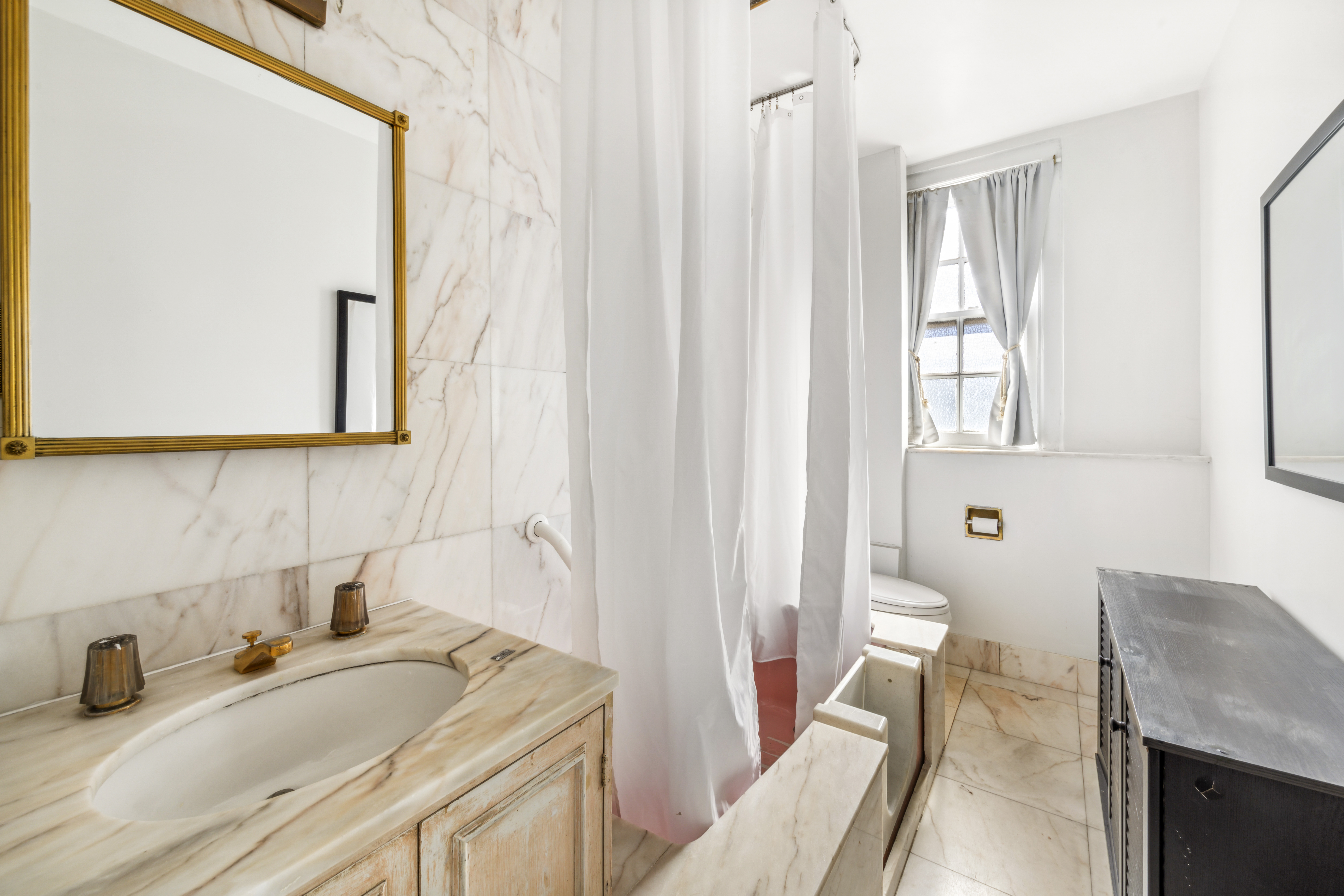 130 East 67th Street, Unit 9C Manhattan, NY 10065 - Photo 17 of 20 a bathroom with a granite countertop sink a toilet and a mirror