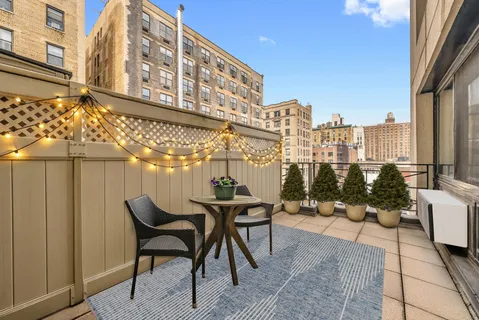 a patio with table and chairs and potted plants