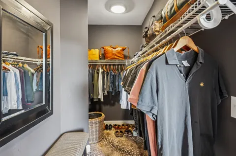 a view of walk in closet with clothes and shoes