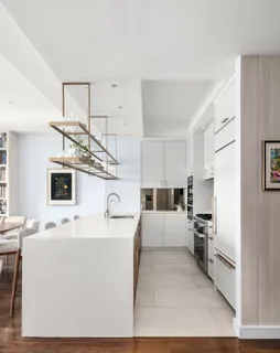 a large white kitchen with cabinets and a wooden floor