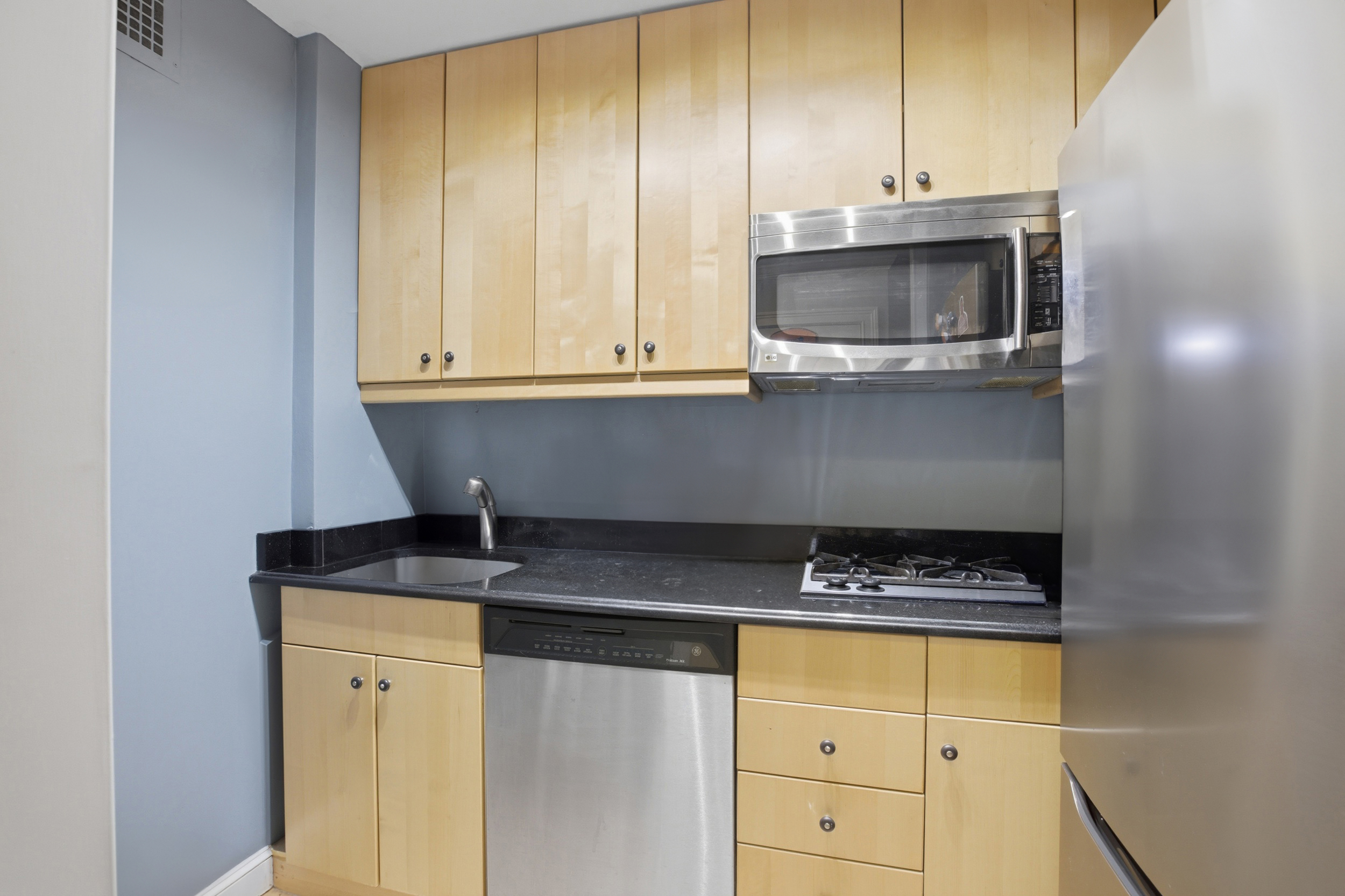 345 East 81st Street, Unit 8G Manhattan, NY 10028 - Photo 5 of 17 a kitchen with granite countertop a sink and cabinets