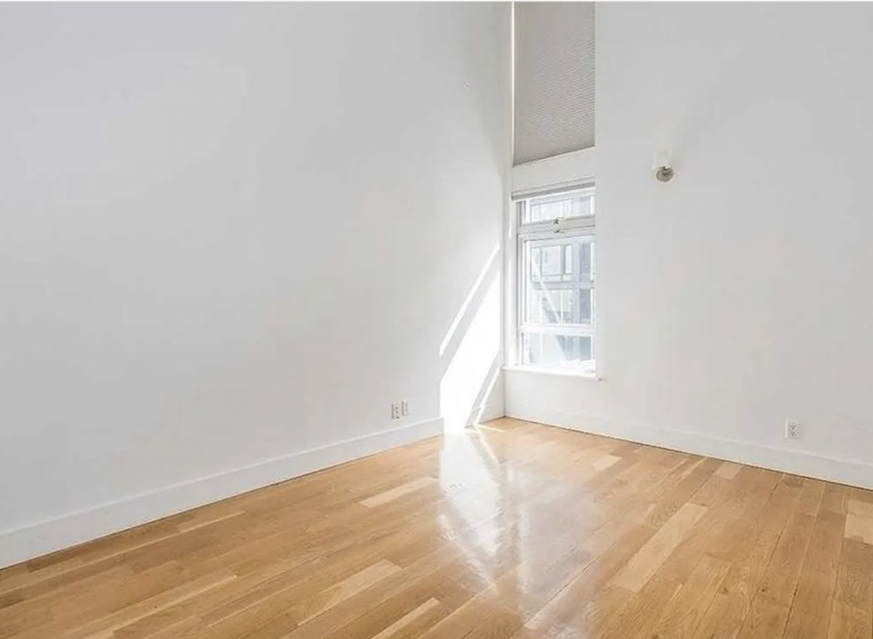 105 Grand Avenue, Unit 1F Brooklyn, NY 11205 - Photo 2 of 7 a view of an empty room with wooden floor and a window