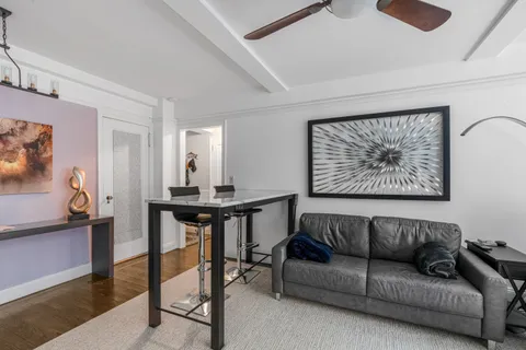 a living room with furniture a rug and a wall painting