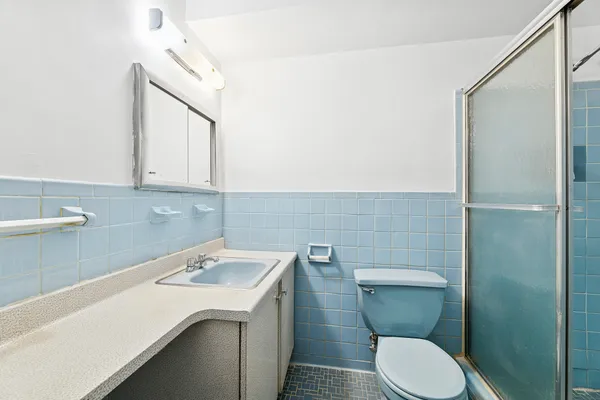 a bathroom with a sink a toilet and a mirror