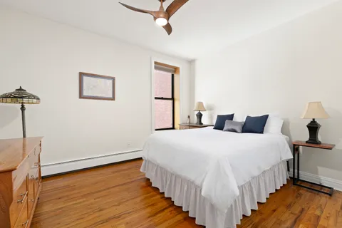 a bedroom with bed and wooden floor