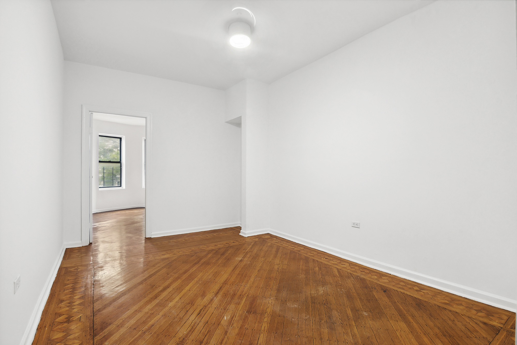 244 New York Avenue, Unit 3L Brooklyn, NY 11216 - Photo 5 of 7 an empty room with wooden floor and windows