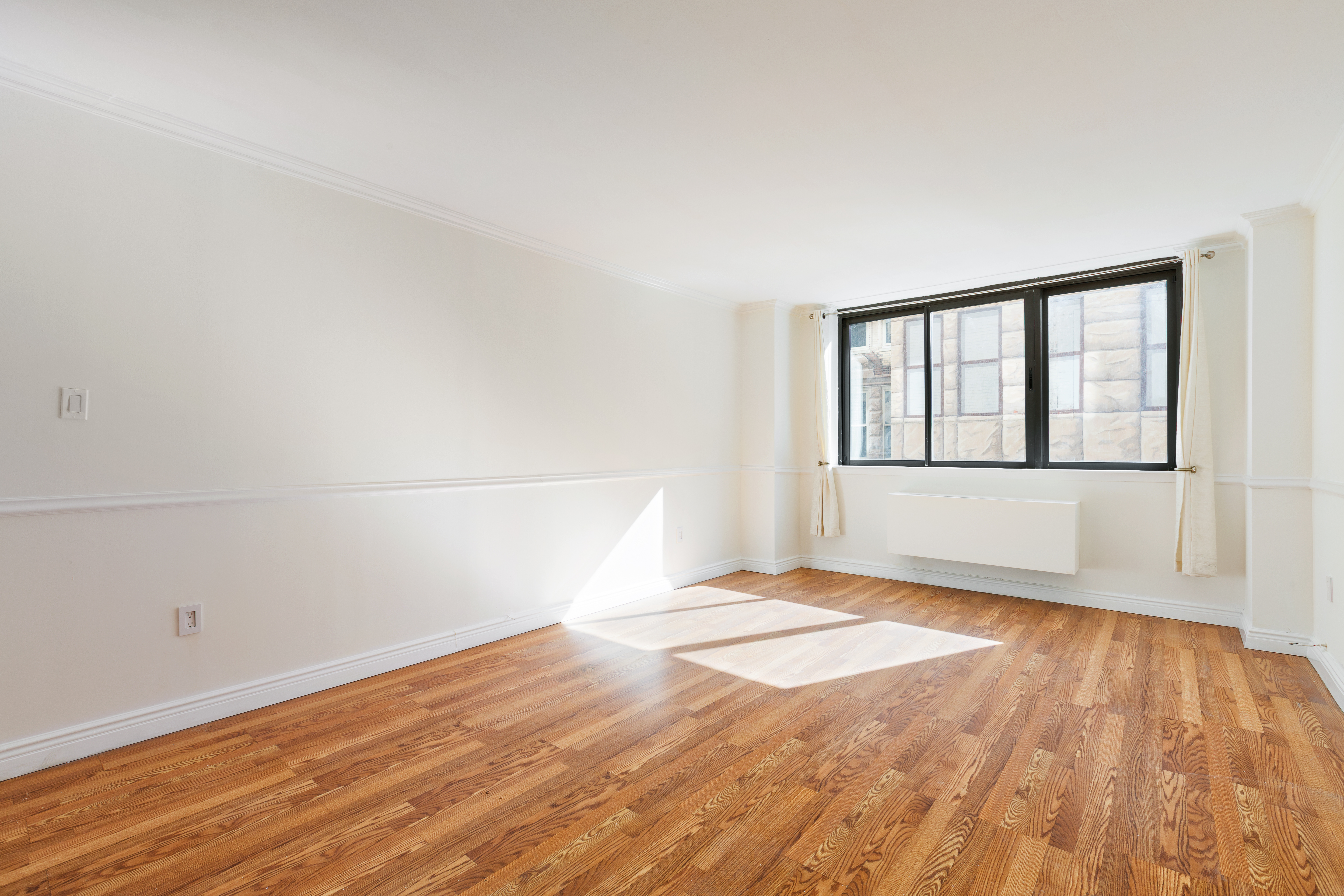 280 Park Avenue South, Unit 4F Manhattan, NY 10010 - Photo 5 of 7 a view of an empty room with wooden floor and a window
