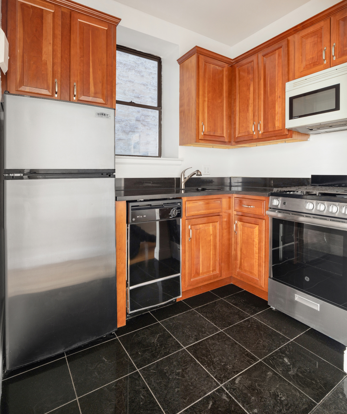 231 East 13th Street, Unit 6E Manhattan, NY 10003 - Photo 3 of 9 a kitchen with granite countertop stainless steel appliances and cabinets