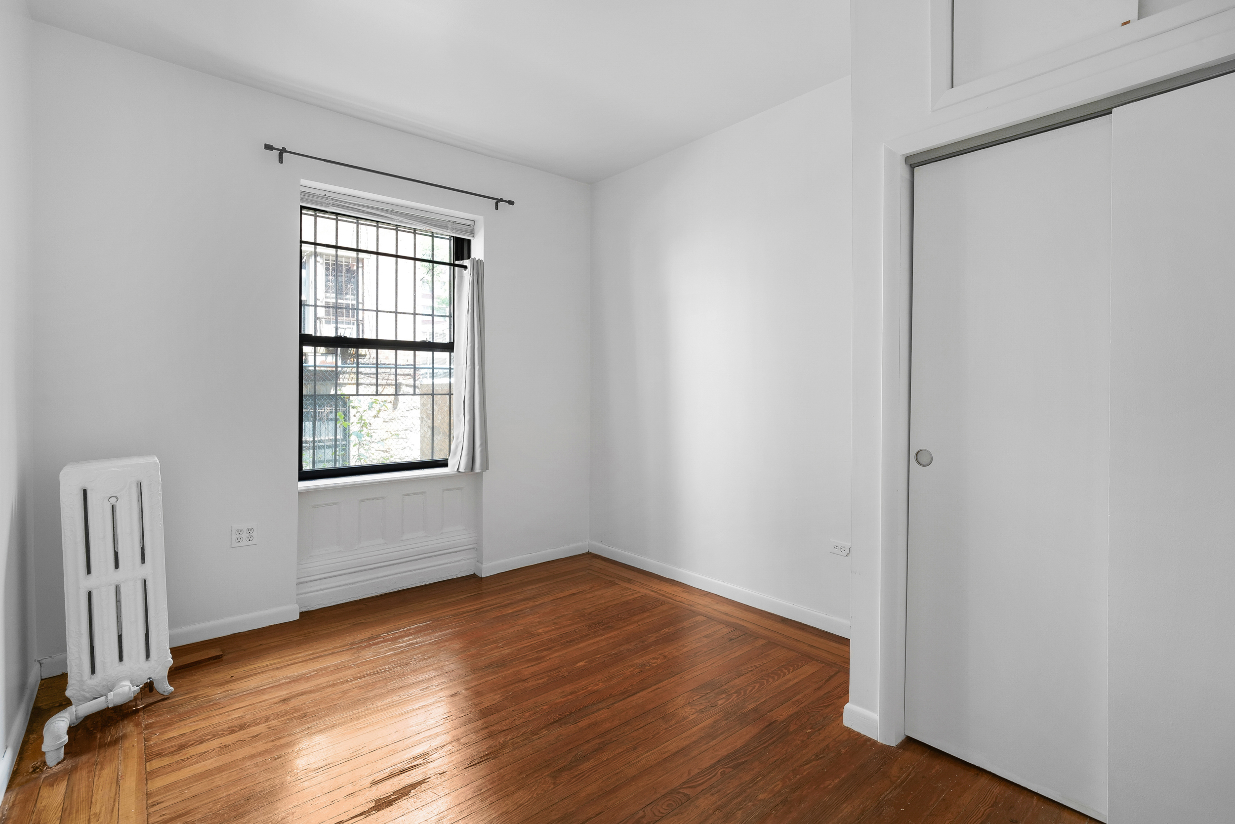 507 West 111th Street, Unit 3 Manhattan, NY 10025 - Photo 8 of 11 an empty room with wooden floor and windows