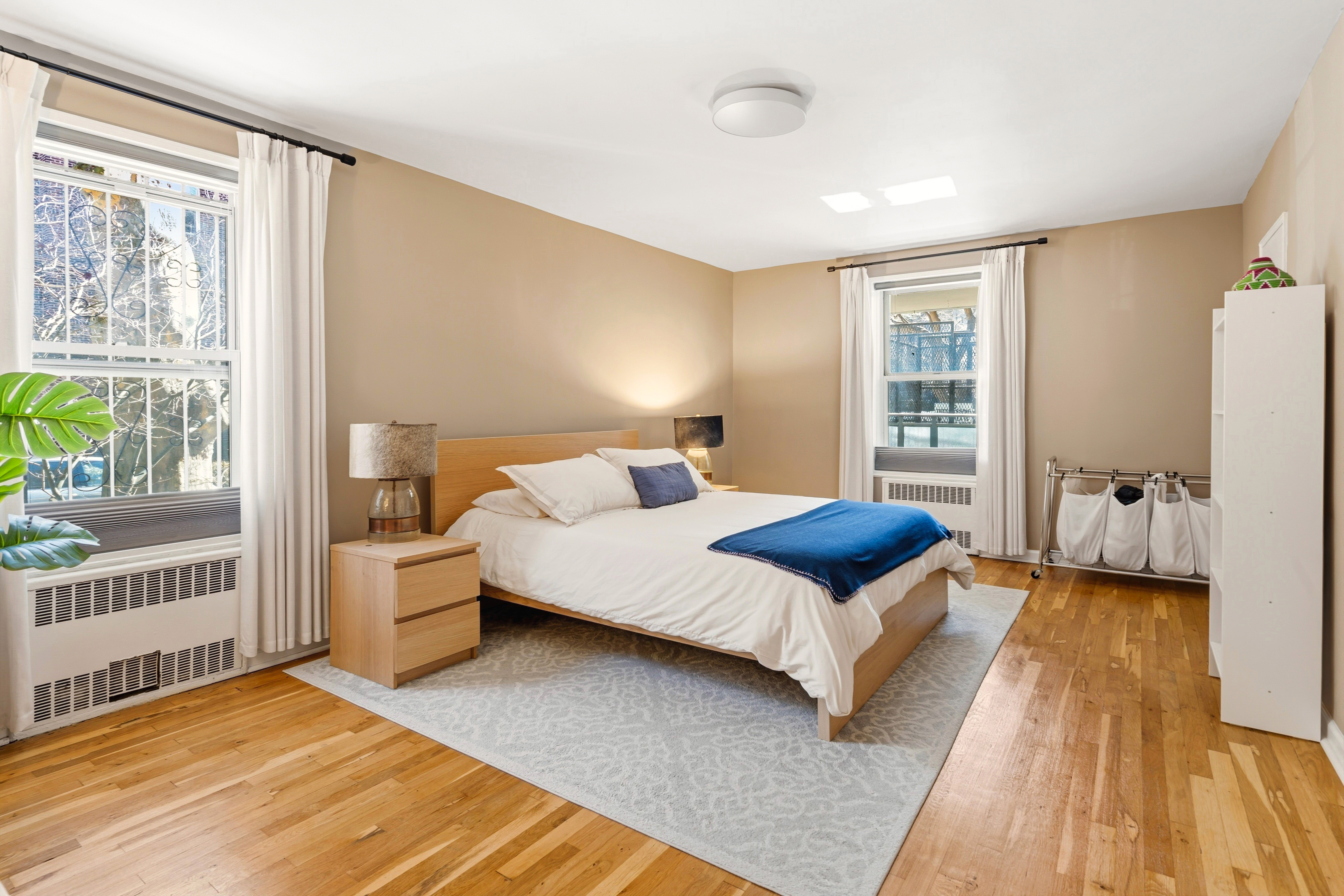 79-10 34th Avenue, Unit 2J Queens, NY 11372 - Photo 4 of 9 a bedroom with a bed and a large window