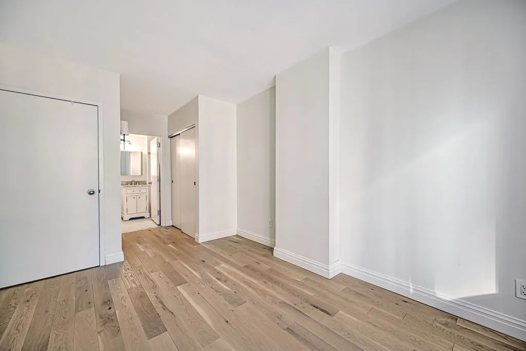 a view of a big room with wooden floor and windows