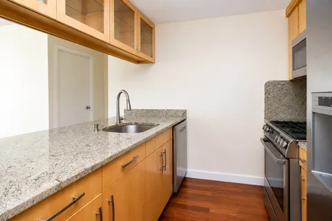 a kitchen with granite countertop a sink and a stove