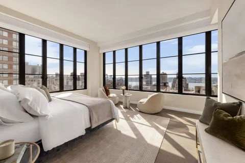 a bedroom with a bed and a large window