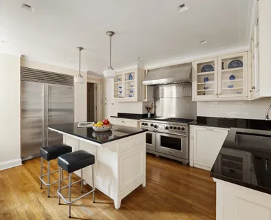 a kitchen with stainless steel appliances kitchen island granite countertop a stove and a refrigerator