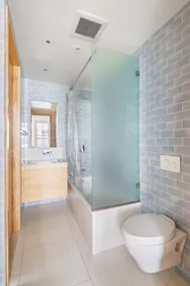a bathroom with a tub a toilet and a shower