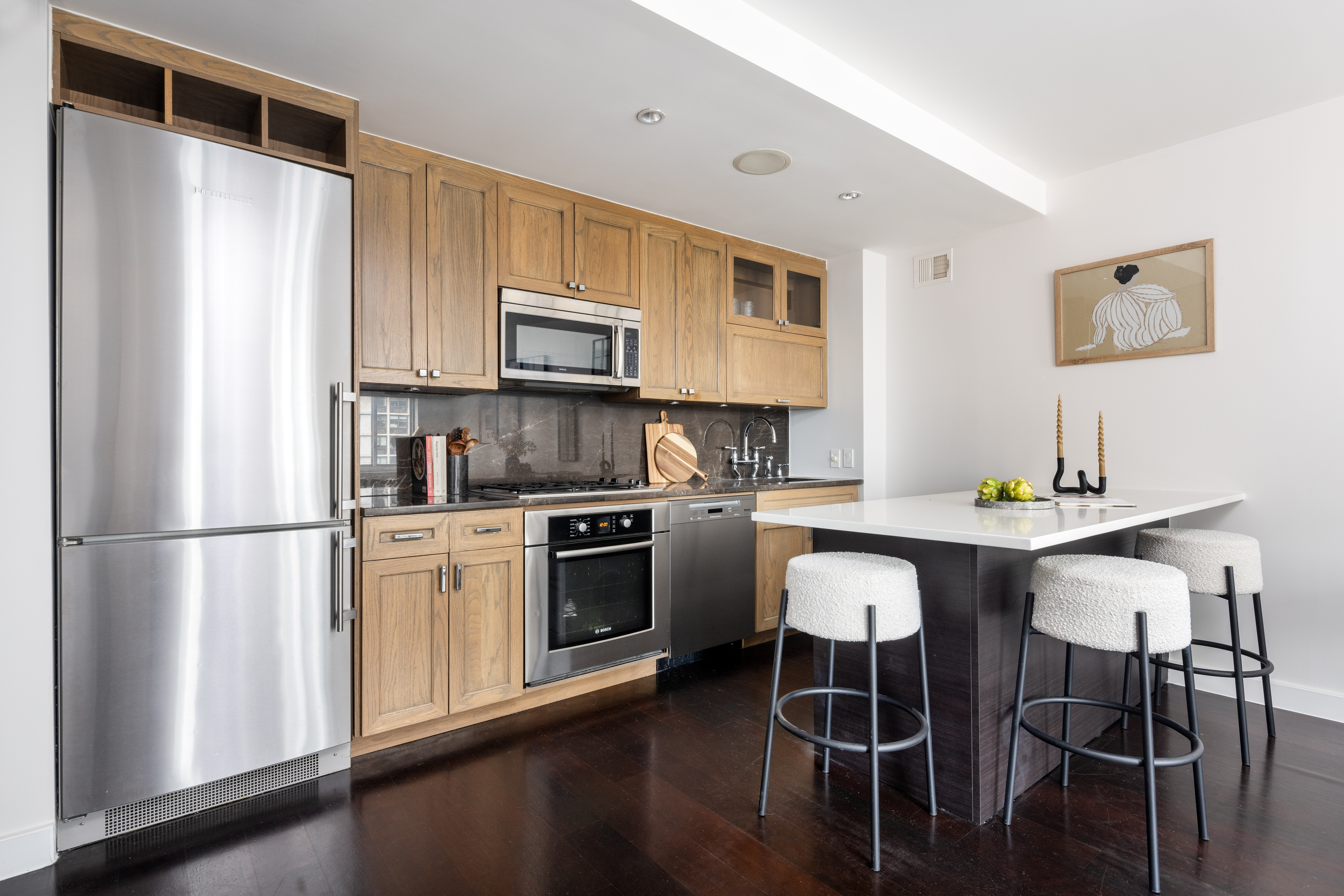 333 Rector Place, Unit 1401 Manhattan, NY 10280 - Photo 3 of 9 a kitchen with a refrigerator a stove a sink dishwasher and white cabinets with wooden floor
