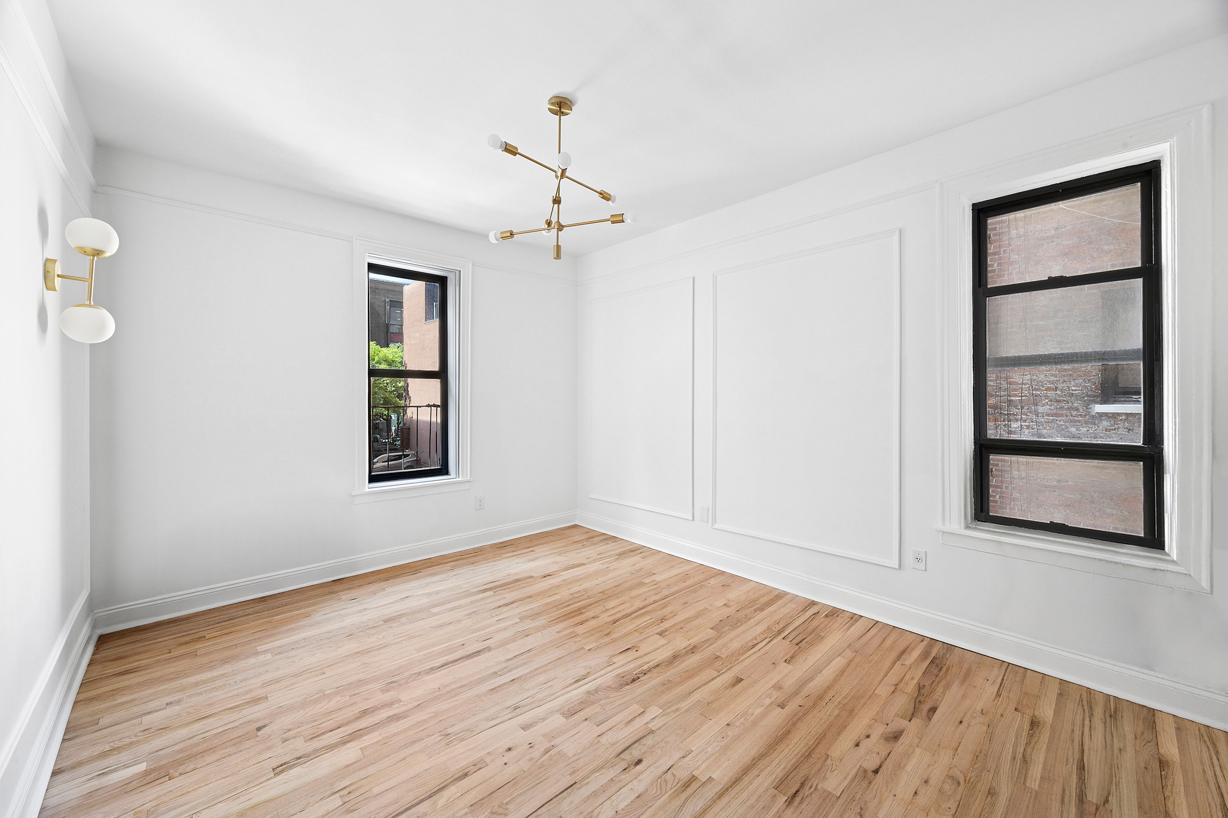 48 West 138th Street, Unit 2F Manhattan, NY 10037 - Photo 6 of 10 a view of an empty room with wooden floor and a window