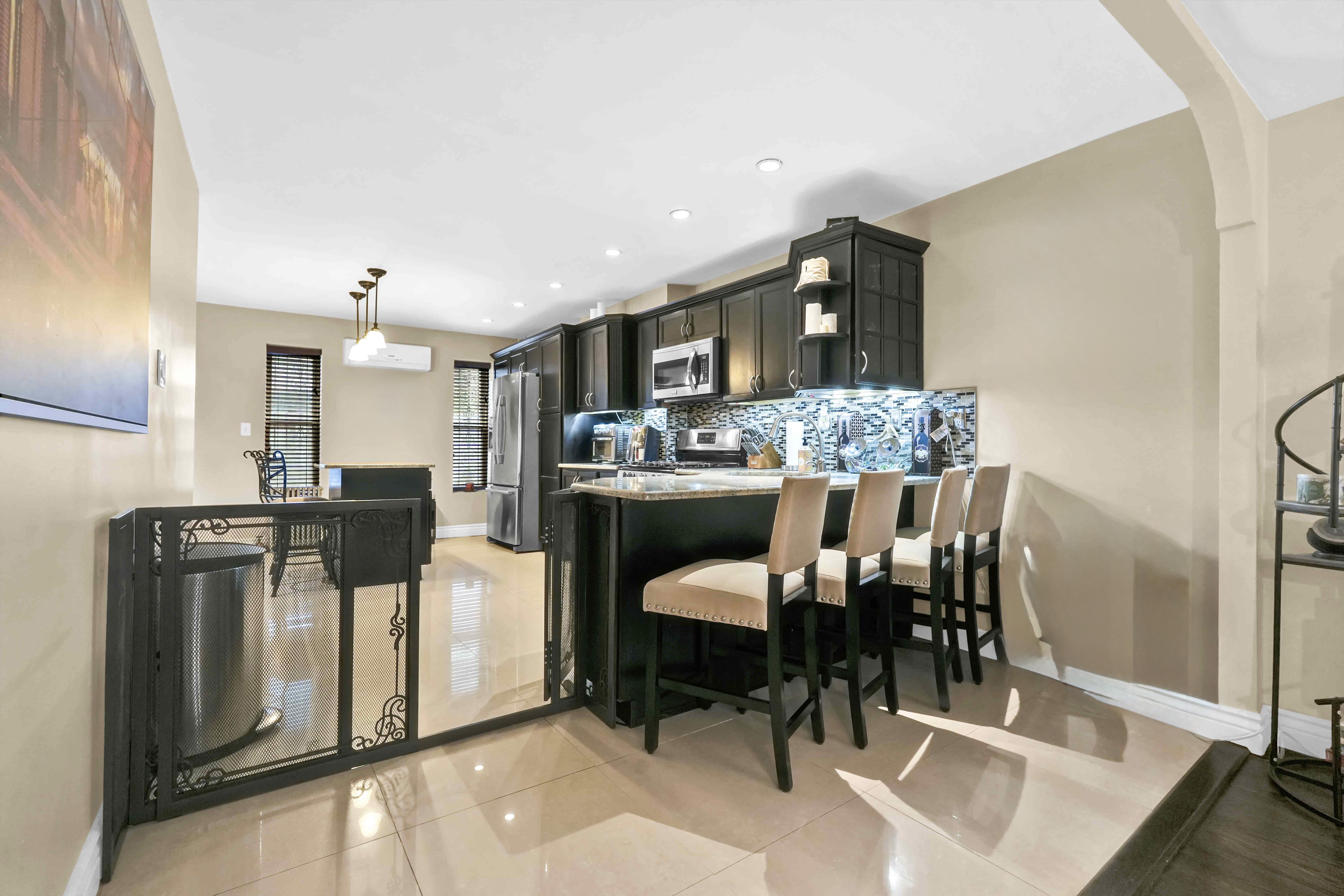 519 Monroe Street Brooklyn, NY 11221 - Photo 33 of 55 a kitchen with stainless steel appliances kitchen island granite countertop a refrigerator and a stove top oven