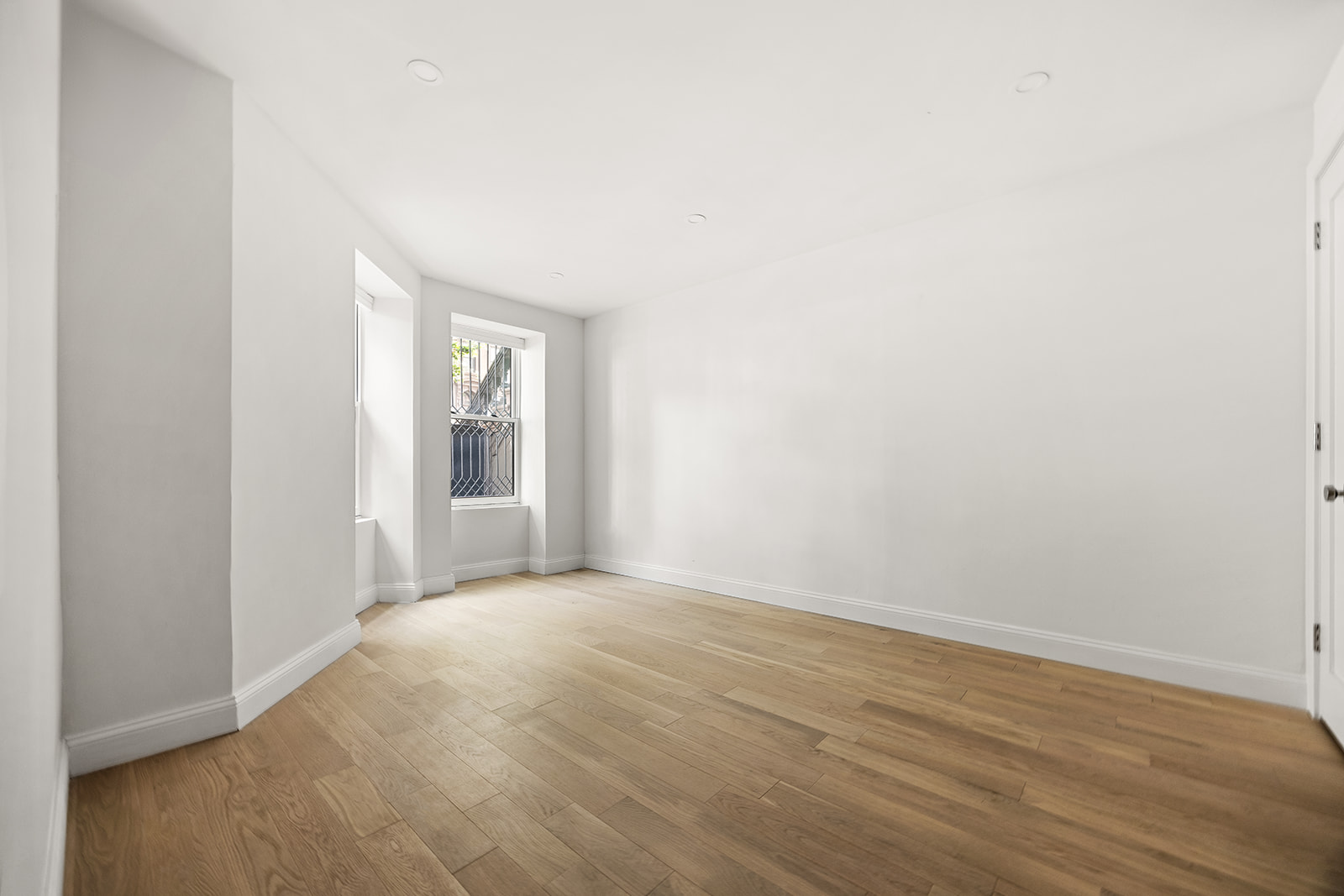 84 6th Avenue, Unit 1 Brooklyn, NY 11217 - Photo 8 of 22 a view of an empty room with wooden floor and a window