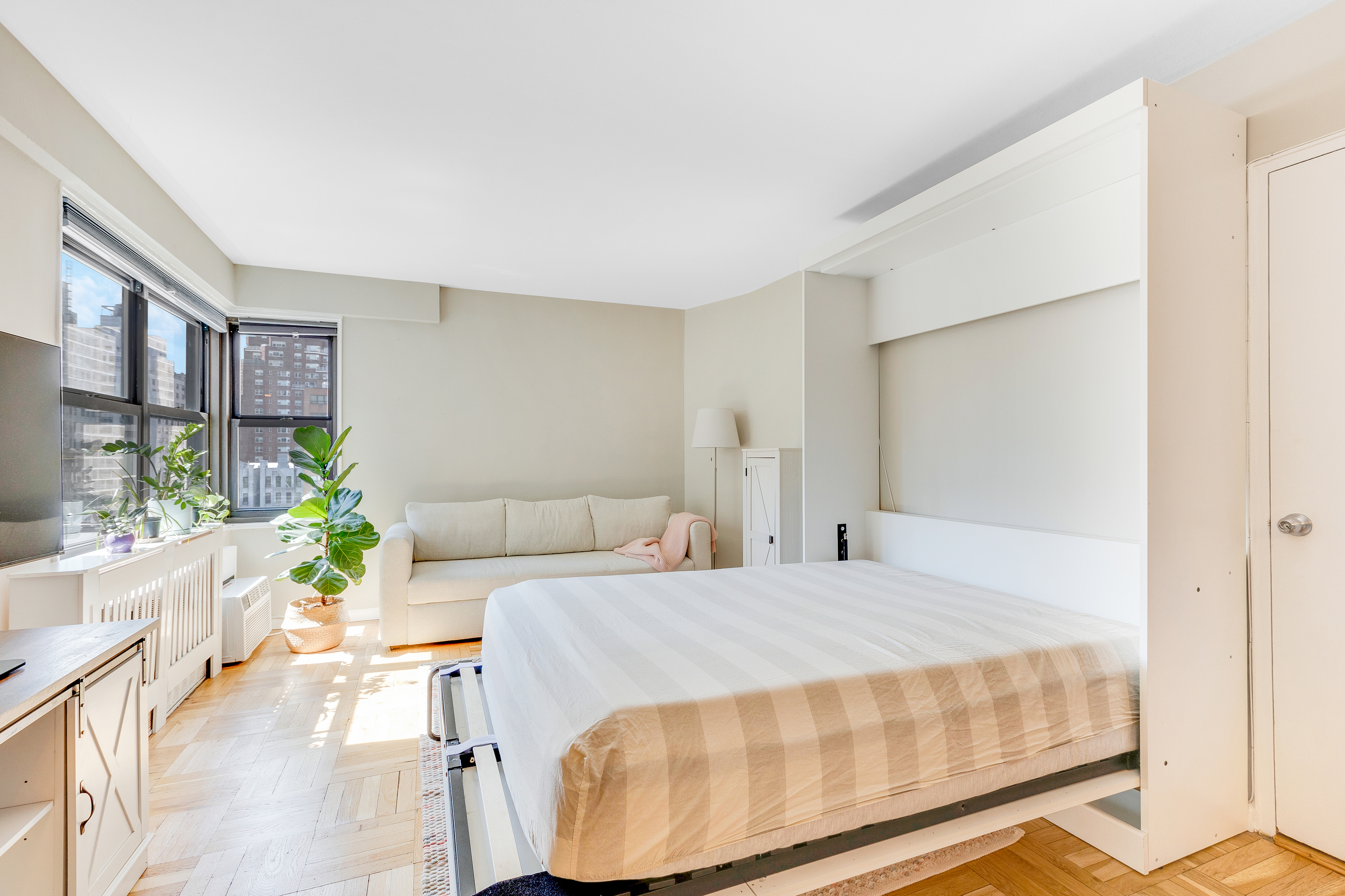 240 East 76th Street, Unit 9A Manhattan, NY 10021 - Photo 2 of 9 a bedroom with a bed a table and chair