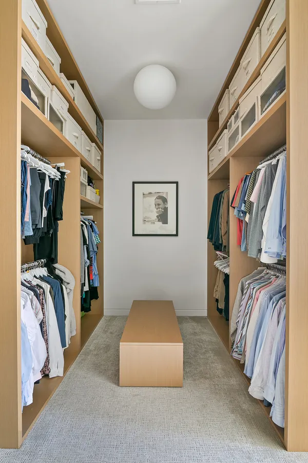 a view of walk in closet with clothes and shoes