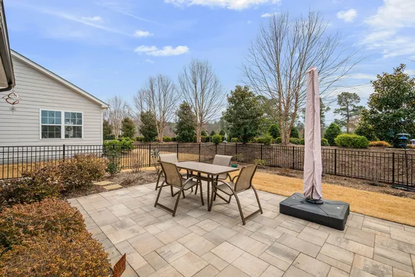 a view of a patio with a table chairs and a floor to ceiling window
