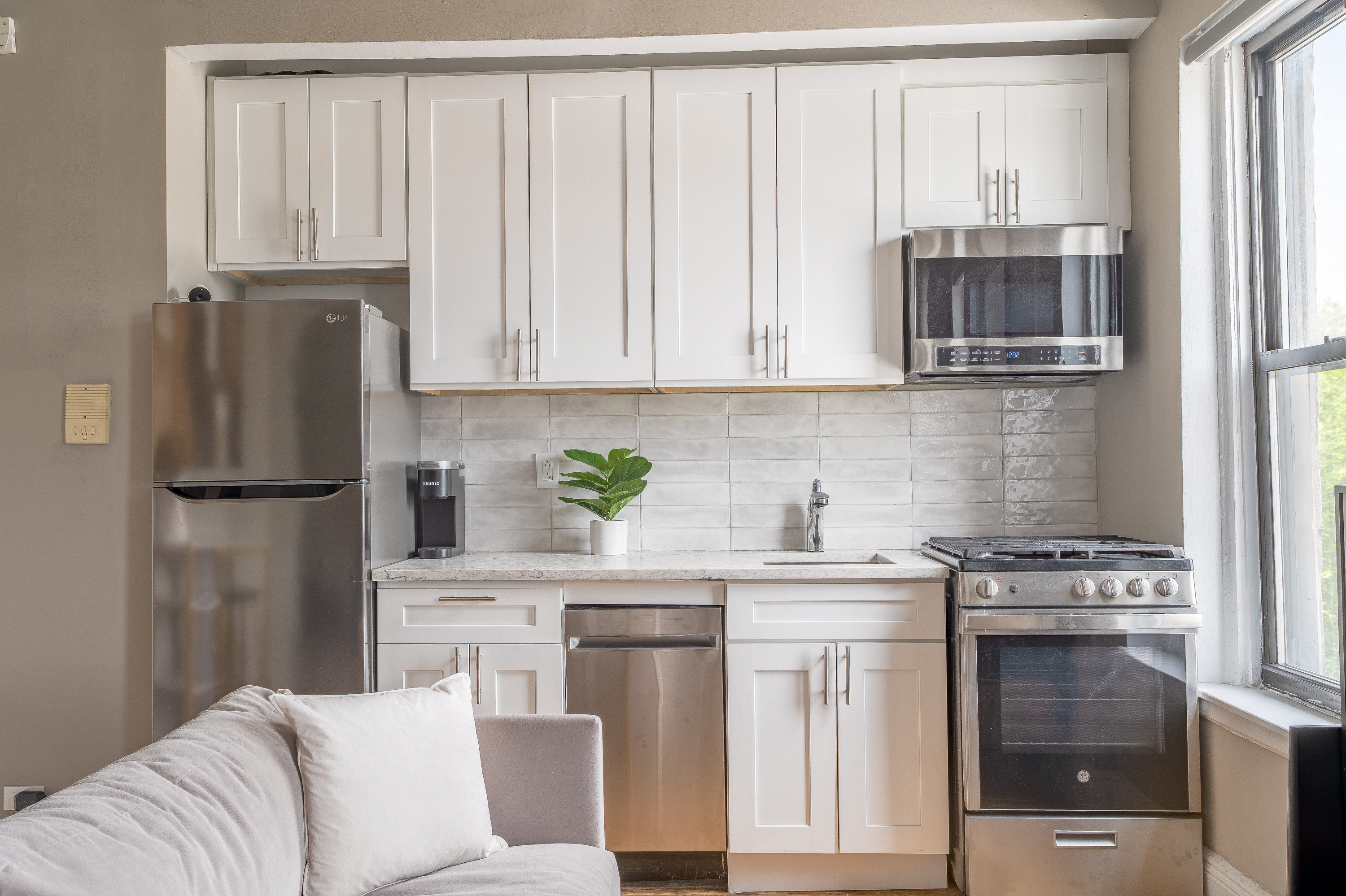 94 Hamilton Place, Unit 6E Manhattan, NY 10031 - Photo 5 of 16 a kitchen with stainless steel appliances granite countertop a refrigerator sink stove and white cabinets