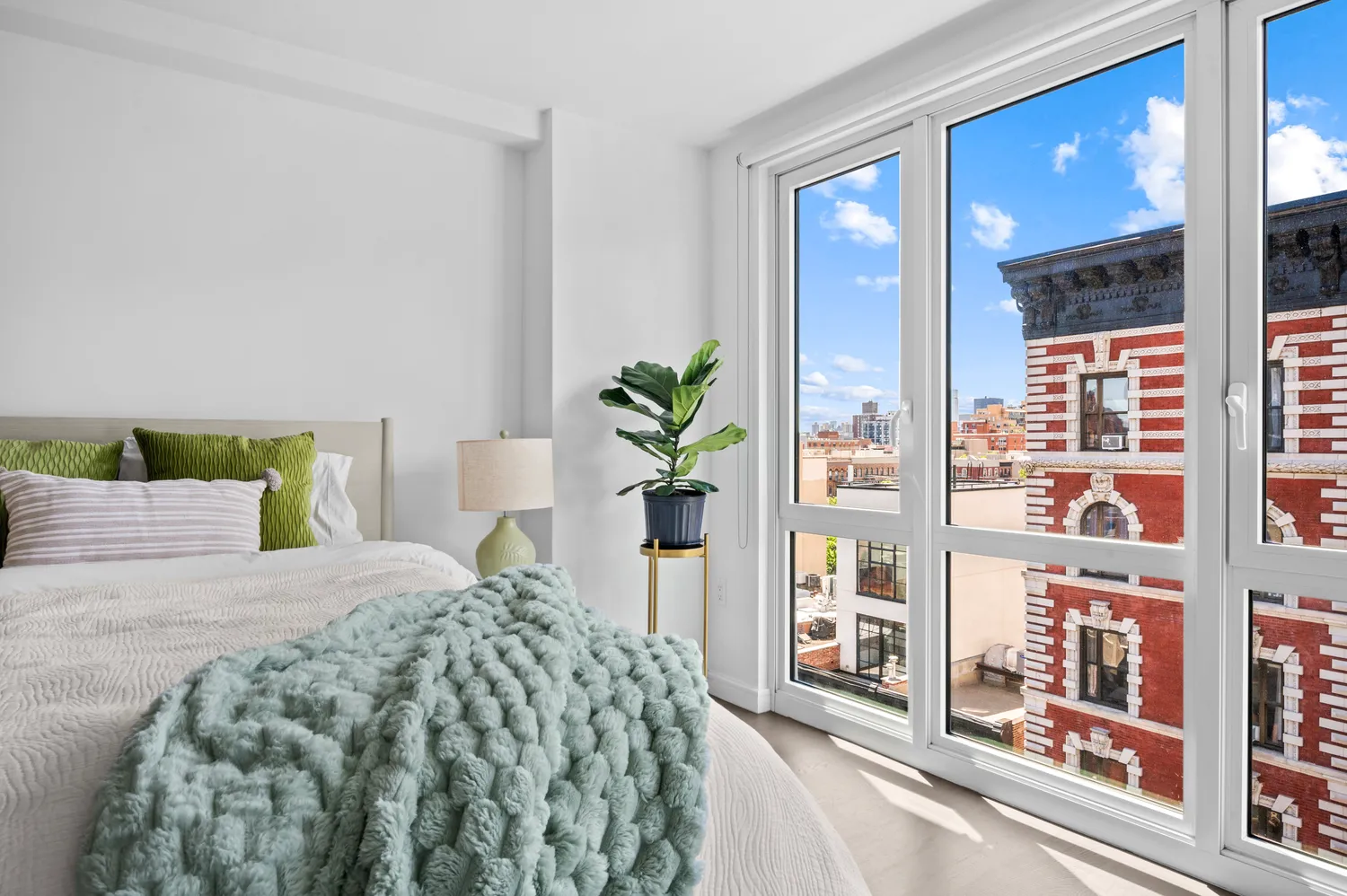 a bedroom with a large bed and a potted plant