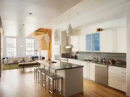 a kitchen with a sink a counter top space and living room view